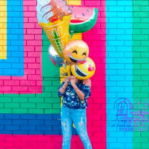 femme avec des ballon smiley pour illustrer l'article sur l'intelligence émotionnelle